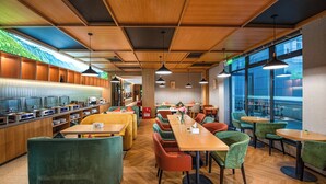 A modern restaurant with wooden ceilings, a buffet area, and comfortable seating.