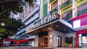 A hotel entrance with a modern design, featuring a prominent sign and a covered entrance area.