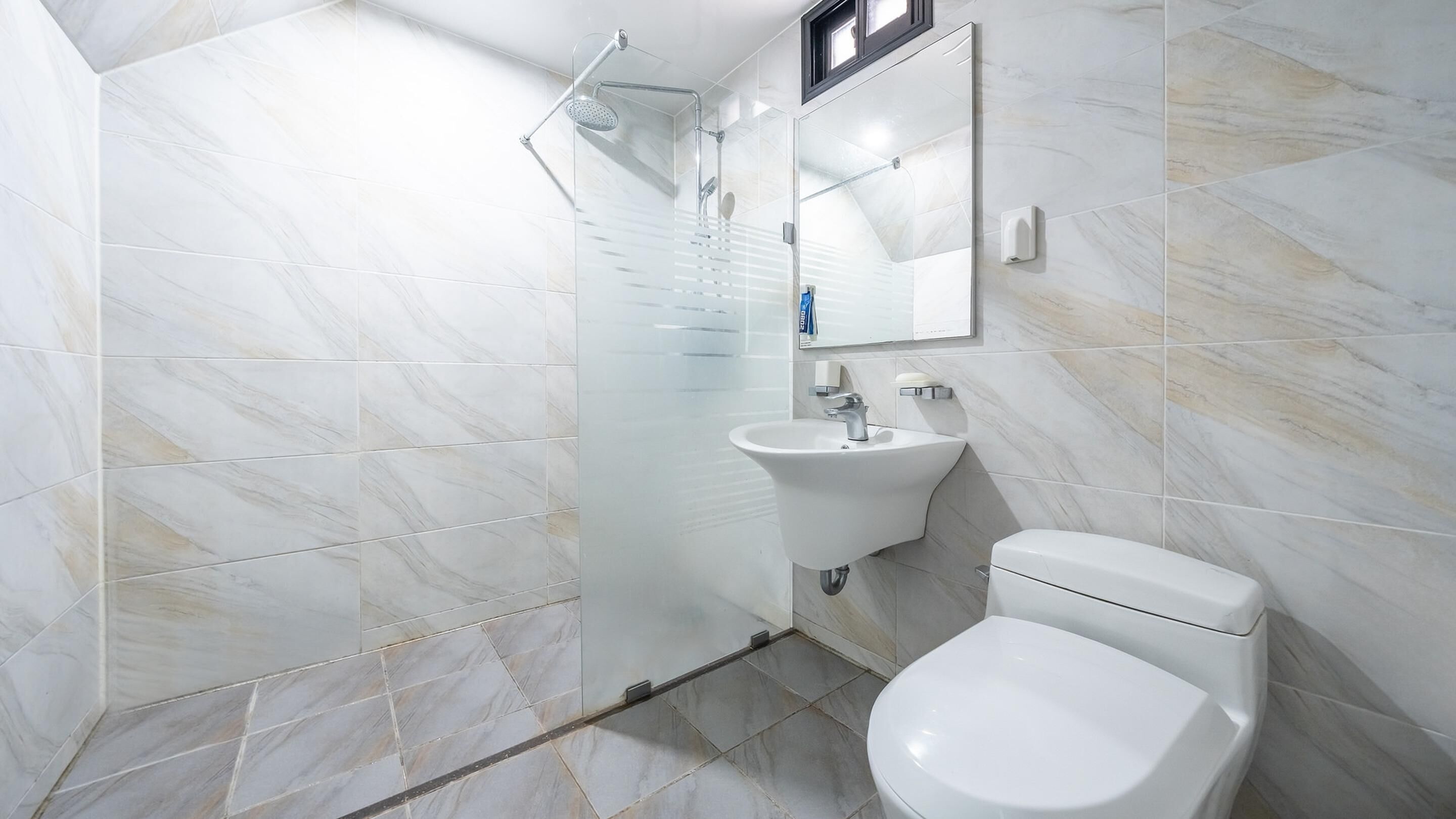 Ein modernes Badezimmer mit Dusche, Waschbecken und Toilette.