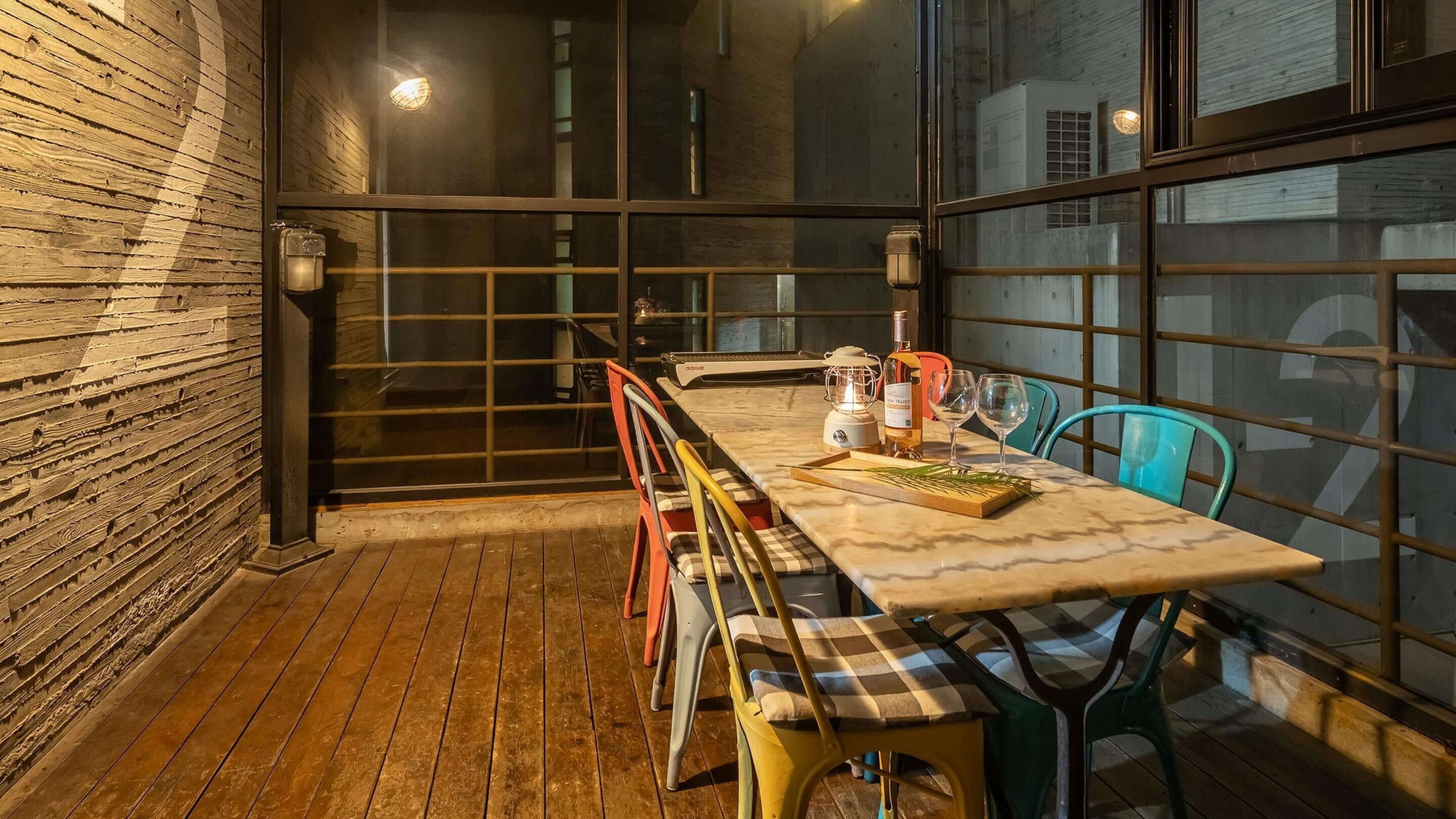 Un comedor acogedor con suelo de madera, una mesa larga y sillas coloridas.