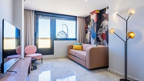 A modern living room with a sofa, chairs, a TV, and a floor lamp. - Smartr Madrid Las Ventas  (Madrid)