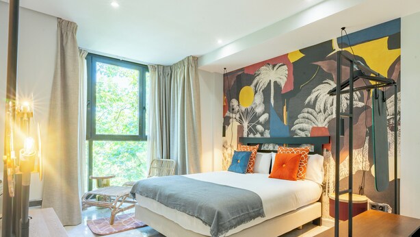 A modern bedroom with a large bed, a wall mural, and a window with curtains. - Smartr Madrid Las Ventas  (Madrid)