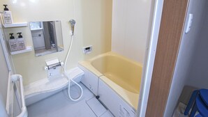 A bathroom with a bathtub, a shower, a toilet, and a sink. There are shelves with toiletries and a mirror above the sink. - Hayashitera 2LDK 6ppl  (Osaka)
