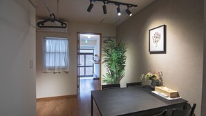 A dining area with a table, chairs, a potted plant, and a framed picture on the wall. - Hayashitera 2LDK 6ppl  (Osaka)