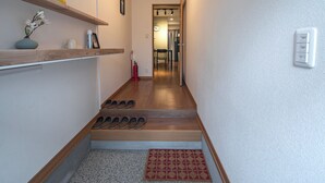 A hallway with wooden steps, a fire extinguisher, and a doormat. - Hayashitera 2LDK 6ppl  (Osaka)