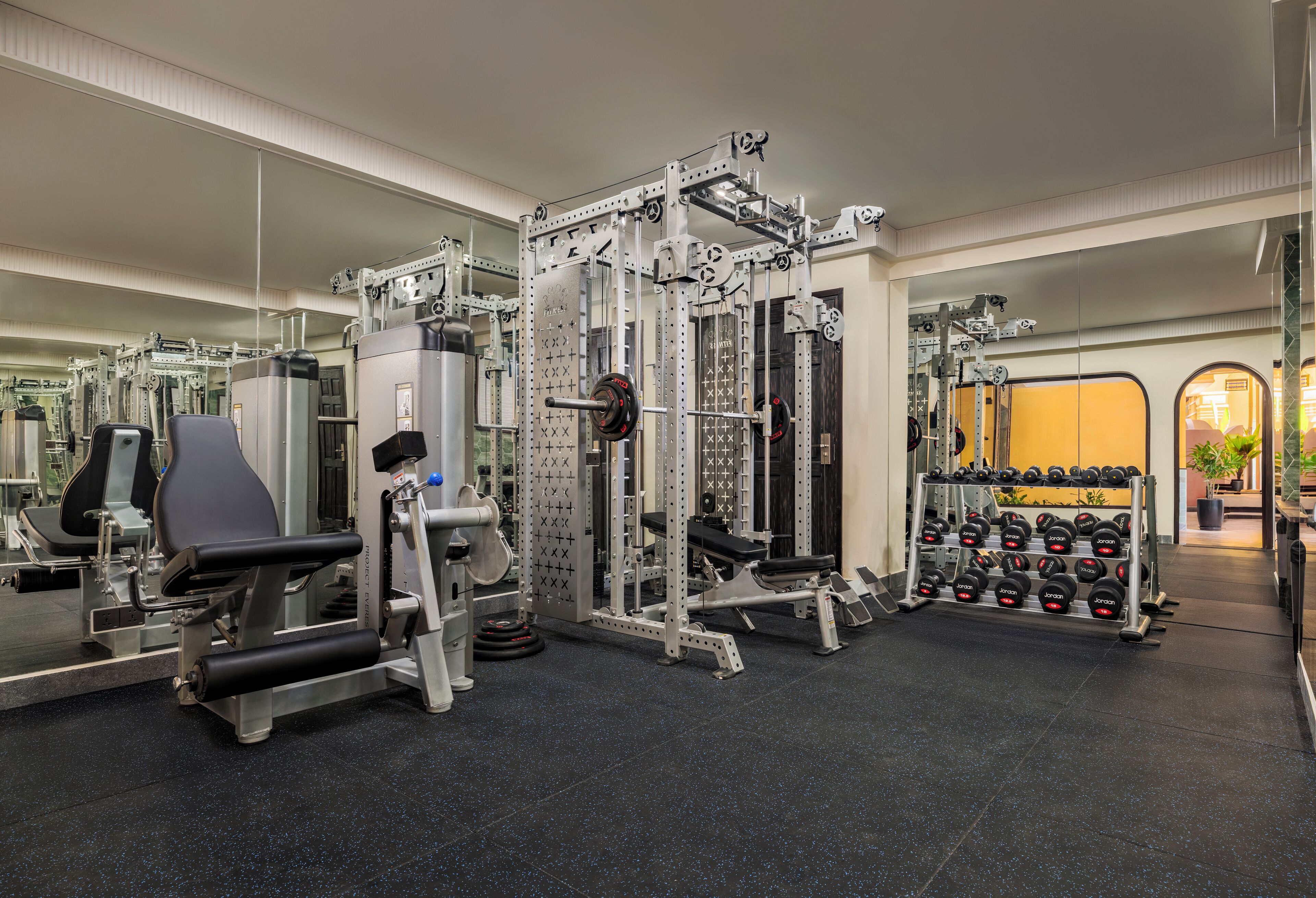 A gym with various exercise equipment, including weight machines and dumbbells.