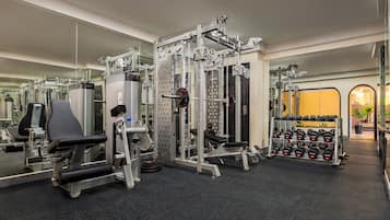 A gym with various exercise equipment, including weight machines and dumbbells.