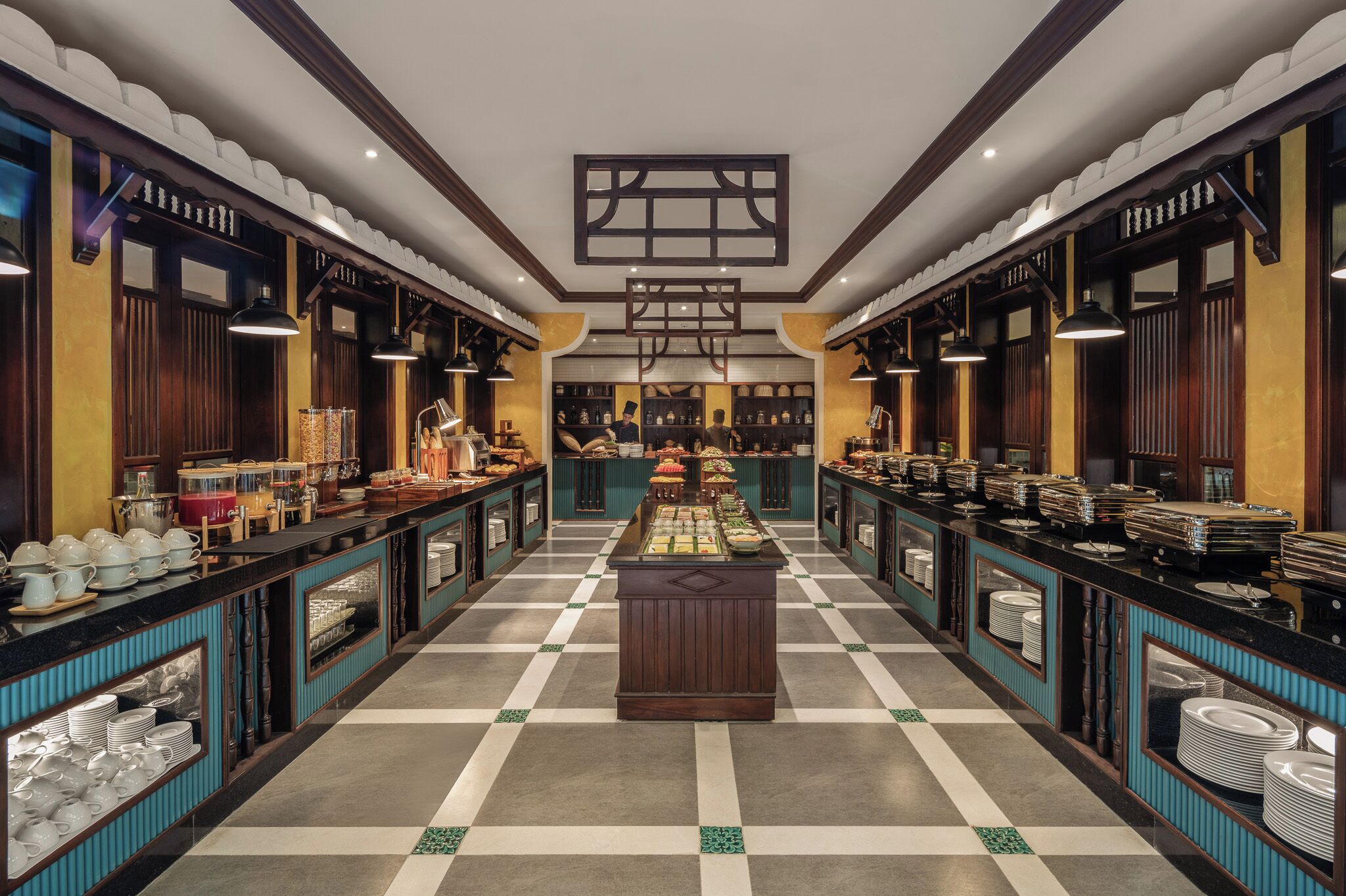 Een buffetopstelling met meerdere aanzit stations, een centraal display en een vloer met een geruit patroon.