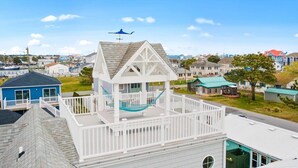 A house with a white exterior, a balcony, and a hammock. - Four Bedroom West OC Home with Pool and Hot Tub (Ocean City)