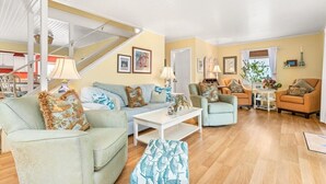 A living room with a staircase, two sofas, a coffee table, and a small side table. - Four Bedroom West OC Home with Pool and Hot Tub (Ocean City)