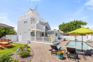 A two-story house with a balcony, a swimming pool, and outdoor seating. - Four Bedroom West OC Home with Pool and Hot Tub (Ocean City)