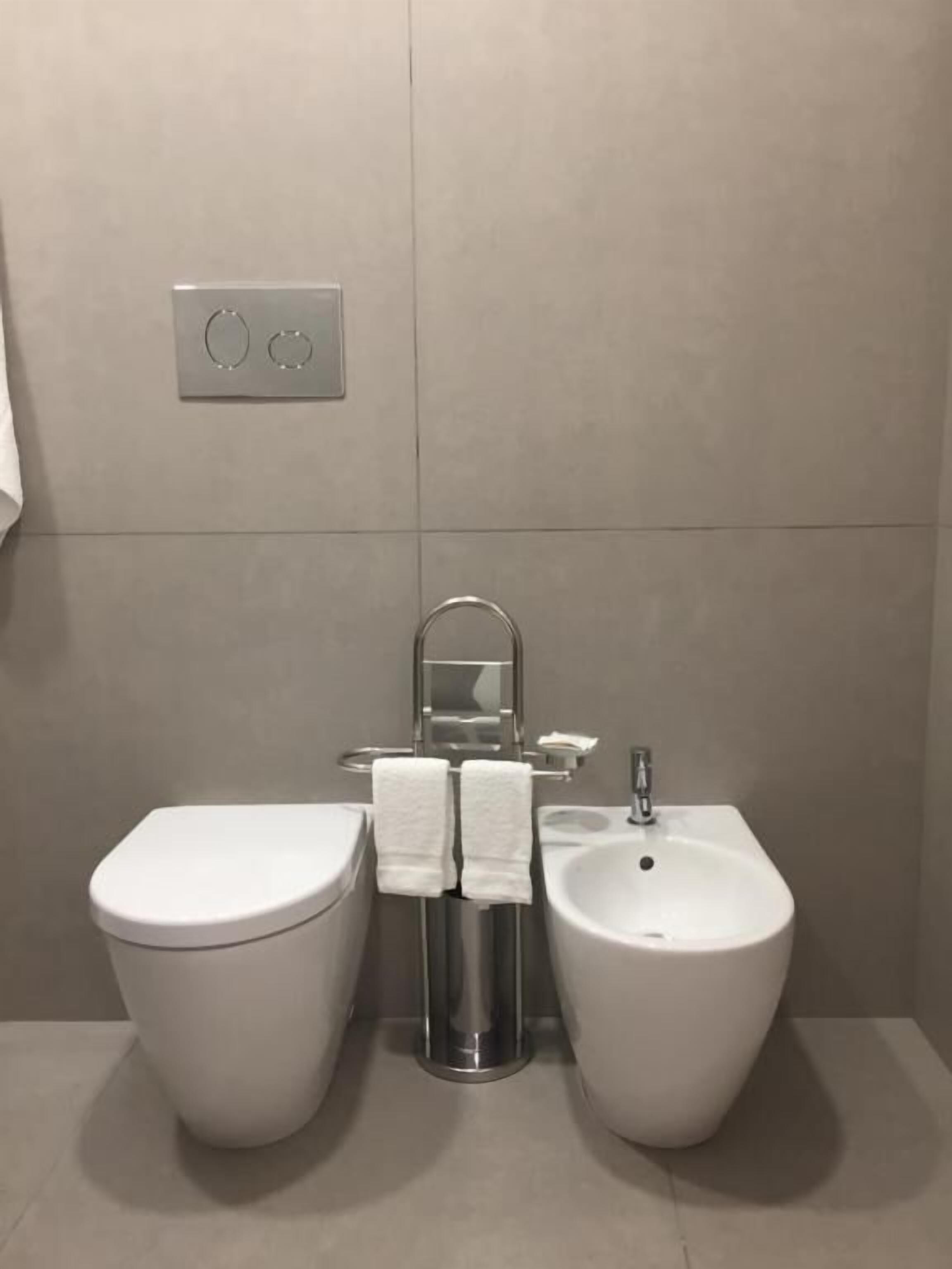 Ein modernes Badezimmer mit Toilette, Bidet und Waschbecken.
