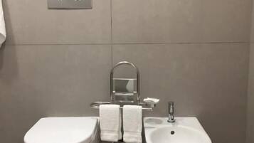 Ein modernes Badezimmer mit Toilette, Bidet und Waschbecken.