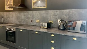 Eine moderne Küche mit eingebautem Backofen, einem Toaster und einem Wasserkocher auf der Arbeitsfläche.