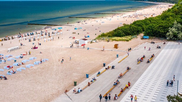 A beach with sun loungers, umbrellas, and a promenade. - Modern-gemütlich Eingerichtetes Appartement in Kołobrzeg City (Kolberg)