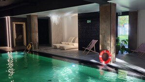 An indoor swimming pool with clear water, a lifebuoy, and lounge chairs. - Modern-gemütlich Eingerichtetes Appartement in Kołobrzeg City (Kolberg)