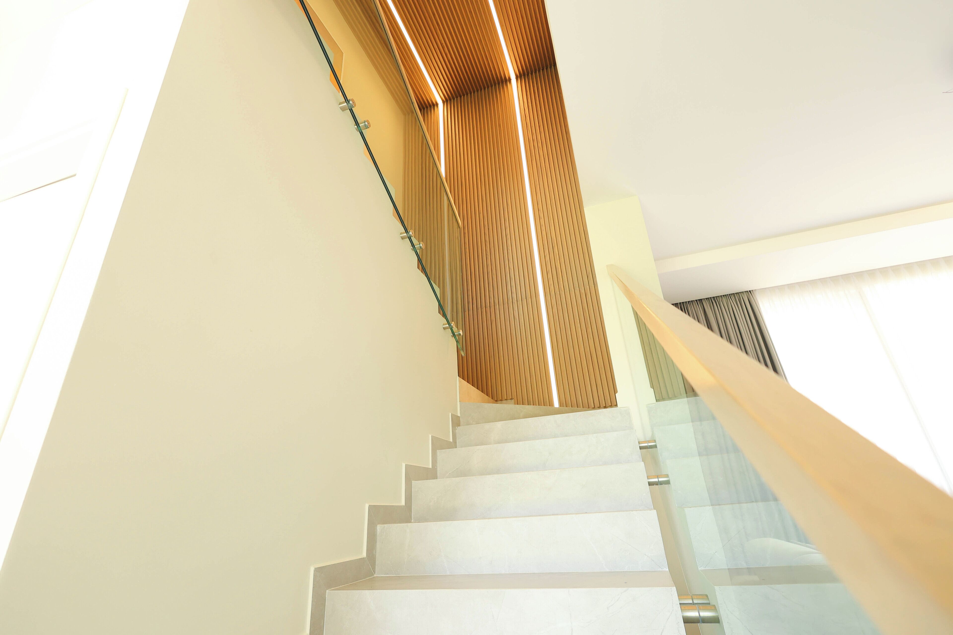 Eine moderne Treppe mit Glastrennstäben und Holzakzenten.
