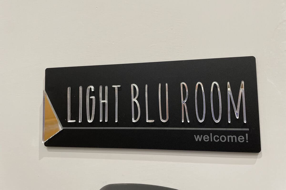 A sign with the text "LIGHT BLU ROOM welcome!"