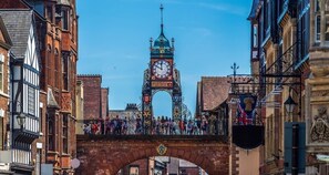 Standing tall, the historic clock tower offers a glimpse into the past, surrounded by traditional buildings and a pedestrian bridge.