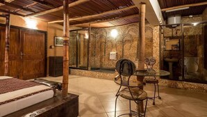 Une pièce comprenant un lit, une chaise en bois, une table et un mur décoratif.