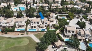 An aerial view of a residential area with multiple houses, swimming pools, and a golf course. - Villa Nausicaa, Aphrodite Hills Golf Resort, Private Heated Pool With Jacuzzi (Kouklia)