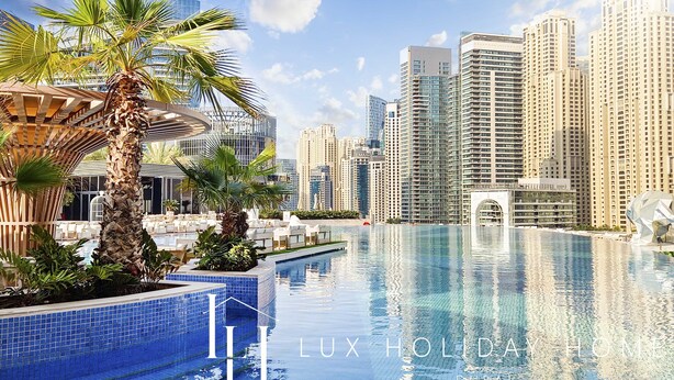 Blick auf einen Pool mit Stadtansicht, Palmen und modernen Gebäuden.