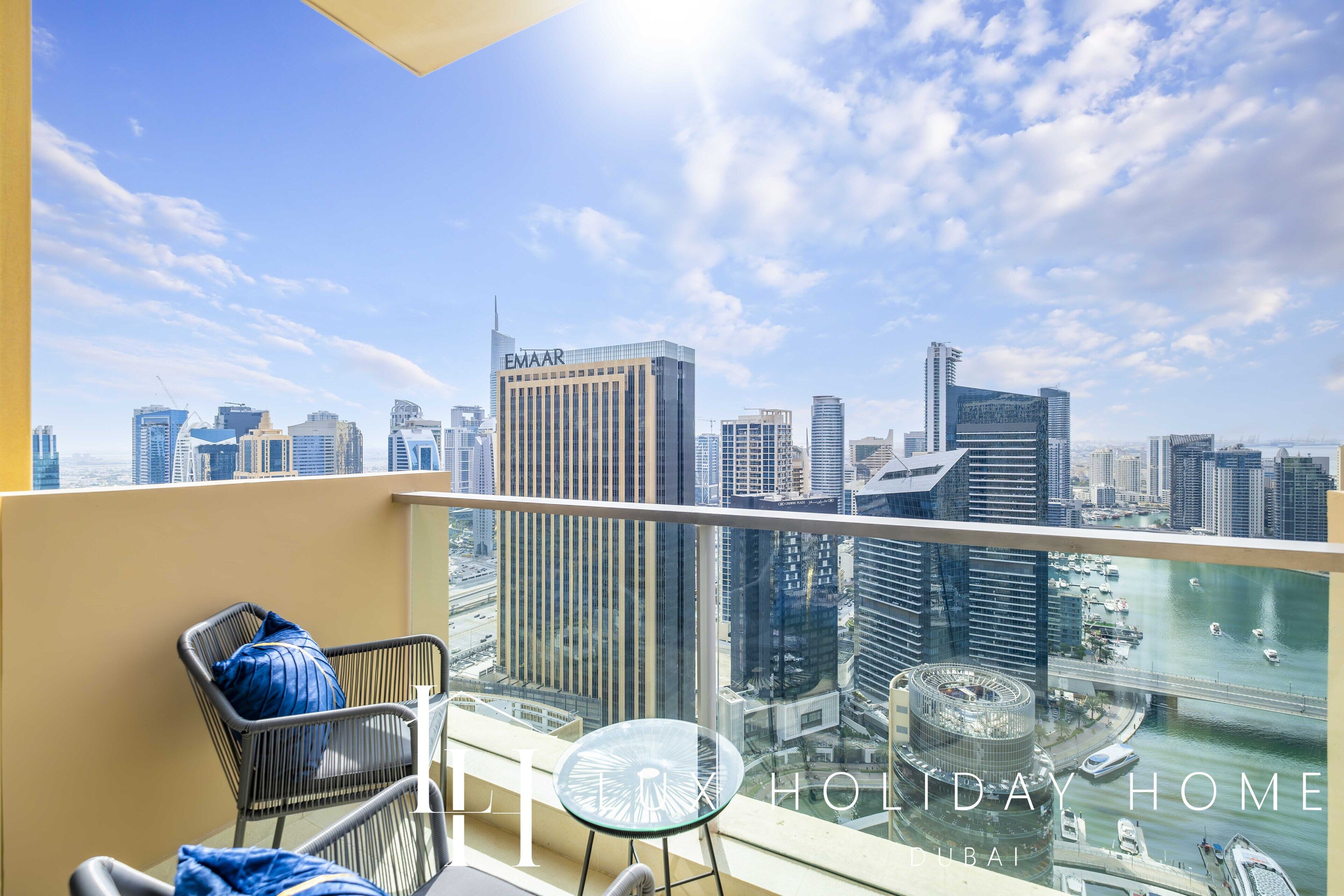 Een balkon met uitzicht op een stadsbeeld, inclusief een gebouw met de tekst 'EMAAR'.