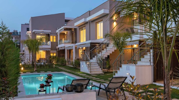 Un immeuble résidentiel moderne doté d’une piscine, d’un espace extérieur aménagé et d’un jardin bien entretenu.