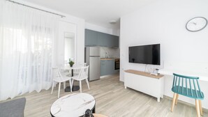 Un appartement moderne comprenant un coin repas, une cuisine et un espace de vie.