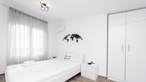 Une chambre à coucher comprenant un lit, une table de chevet, une armoire et une décoration représentant une carte du monde.