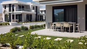 Un moderno edificio residencial con un patio que tiene mobiliario para exteriores.