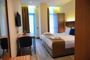 A hotel room with a bed, a desk, a chair, a television, and a wardrobe. - New wave apart hotel (Batumi)