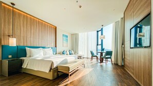 A modern hotel room with a large bed, a desk, and a seating area. - Ha Long Bay Luxury Homestay (Bai Chay)