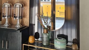 A room with a black cabinet, a mirror, and a yellow wall. - Quintessential Hotel Port Harcourt (Port Harcourt)