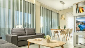 Una sala moderna con sofá, mesa de centro y comedor.