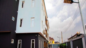 A narrow alleyway between buildings with a clear sky. - Delight Apartments Oniru VI (Lagos)