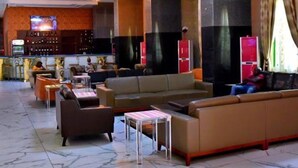 A spacious lobby with a bar area, seating arrangements, and a television screen. - Delight Apartments Oniru VI (Lagos)