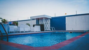 A swimming pool with white lounge chairs and a covered seating area. - Delight Hotel and Suites Ado Ekiti (Ado Ekiti)