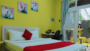Een hotelkamer met een bed, een klein tafeltje met fruit en uitzicht op buiten.