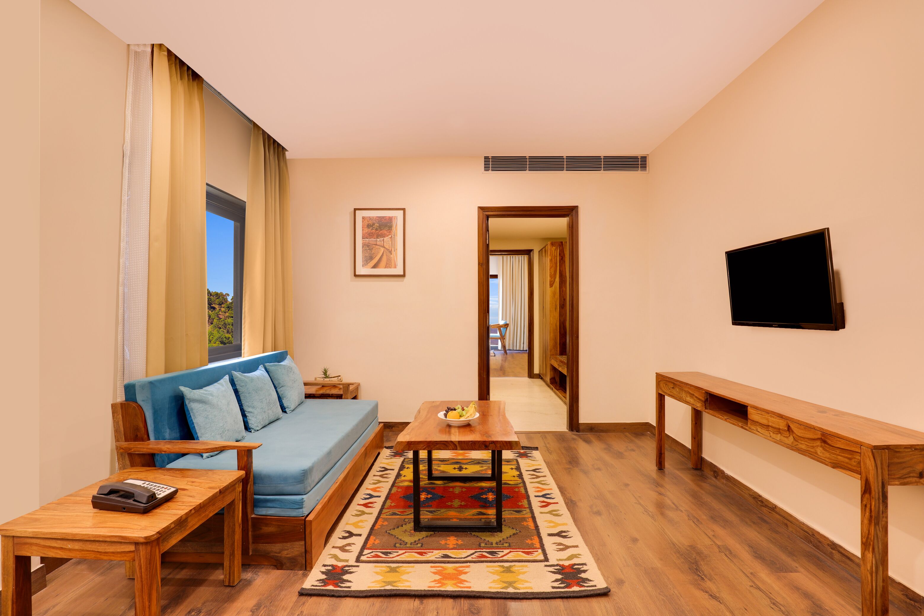 Una sala de estar moderna con sofá, mesa de centro y televisor.