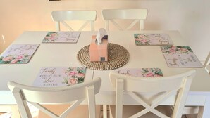 Une table à manger avec quatre chaises, un set de table et une boîte à mouchoirs.
