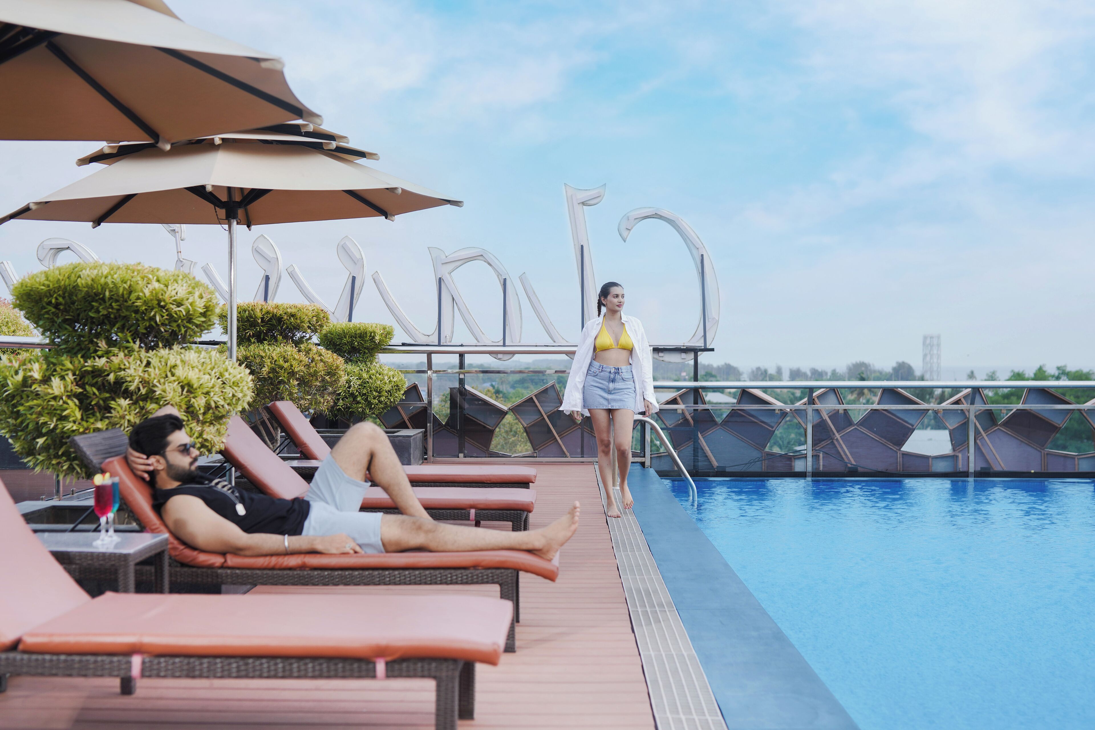 A poolside area with lounge chairs, umbrellas, and a clear view of the pool.