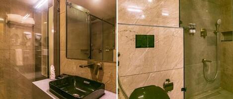 A modern bathroom with a glass shower enclosure, a green toilet, and a marble-tiled wall.