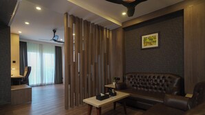 Un salon moderne avec un canapé en cuir, une table basse en bois et un ventilateur de plafond.