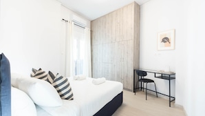A modern bedroom with a bed, a desk, and a chair.