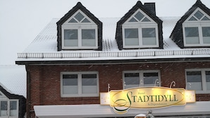 A hotel with a prominent 'Hotel Stadthyll' sign, a brick facade, and snow-covered surroundings. - Hotel Stadtidyll (Rotenburg)