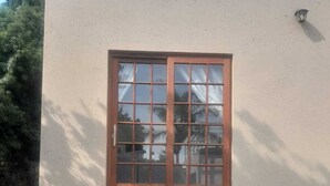 Una ventana con marco de madera y una pequeña escalera de madera que lleva hasta ella.