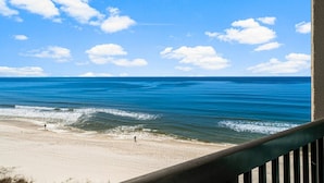 Een strand met heldere lucht en golven.
