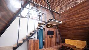 A modern interior with a wooden staircase, a sofa, and a television. - Sunflower Saga (Jamwa Ramgarh)