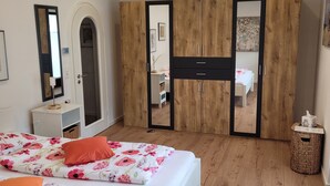 Un dormitorio con dos camas, un armario de madera y un espejo.